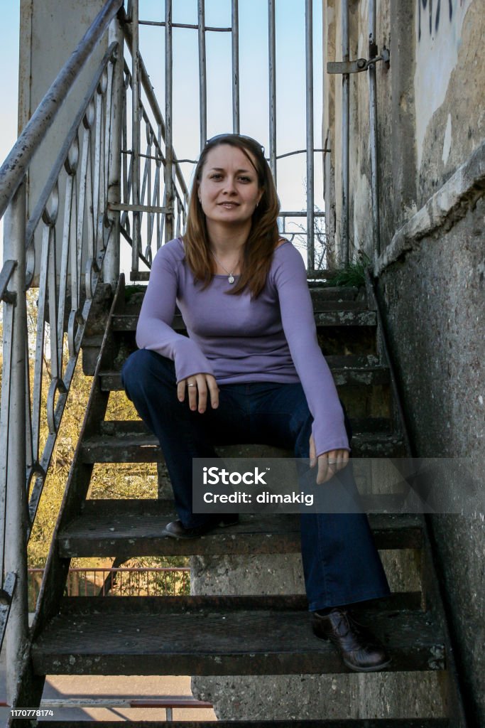 2010.10.10, Obninsk, Russia. Long hair woman sitting on the stairs, front side view. Portrait of a beautiful woman. 2010.10.10, Obninsk, Russia. Long hair woman sitting on the stairs, front side view. Adult Stock Photo