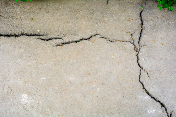 istock Worn and cracked asphalt with big cracks. Old road concrete texture 1170782834