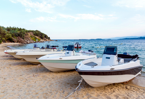Boats for renting standing side by side on sand in Chalkidiki, Athos peninsula, Greece.