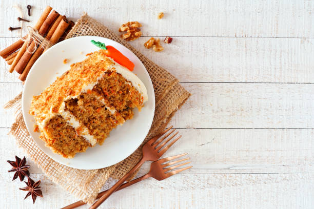 fetta di torta di carote fatta in casa con glassa al formaggio cremoso, sopra la vista sullo sfondo in legno bianco - cake carrot carrot cake dessert foto e immagini stock
