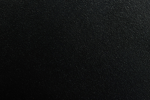 Dark matte metal background macro close up view. Black texture with granule
