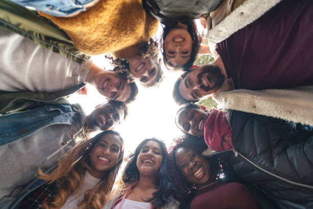 multiethnische gruppe von universitätsstudenten mit blick nach unten - friendship young adult group of people multi ethnic group stock-fotos und bilder