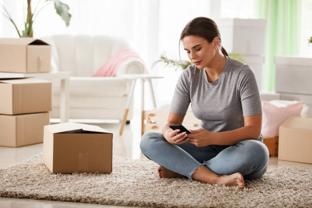 istock Young woman taking a break from packing and using her mobile phone 1170793673
