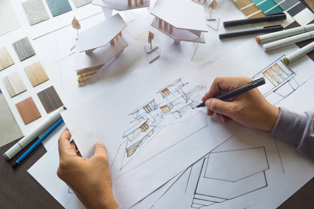 istock architect design working drawing sketch plans blueprints and making architectural construction model in architect studio 1170793862