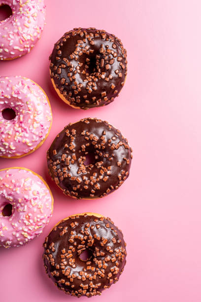Colorful donuts on rose background
