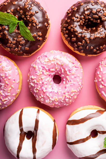istock Colorful donuts on rose background 1170795558