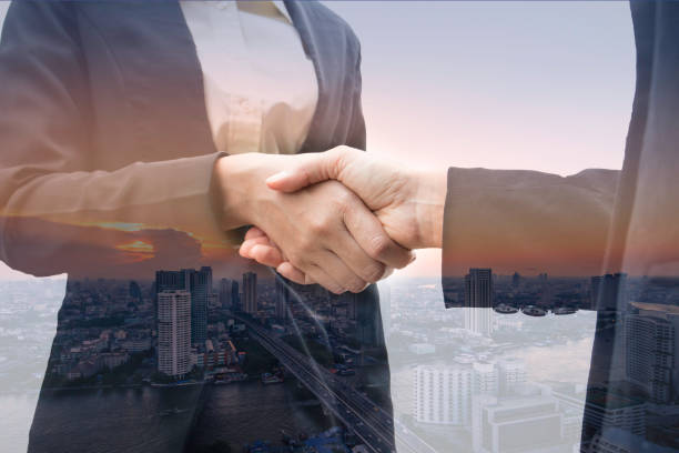 istock Business man and woman hand shake with multi exposure background 1170797179