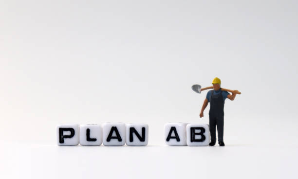 istock The white cube of 'PLAN A, B' text with miniature people. 1170804312