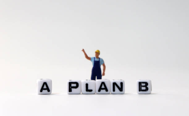 istock The white cube of 'PLAN A, B' text with miniature people. 1170804909