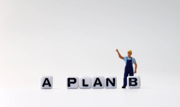 istock The white cube of 'PLAN A, B' text with miniature people. 1170804928
