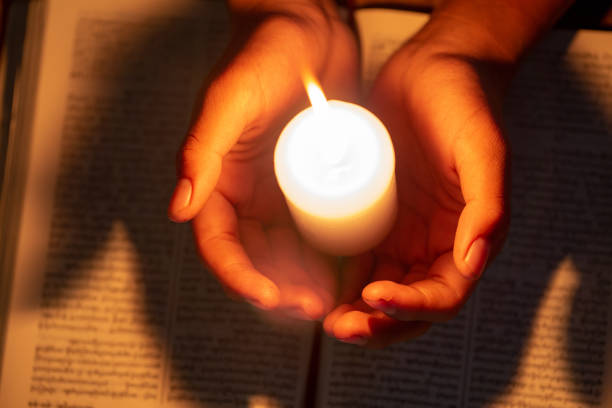 종교적 개념, 그 젊은이는 방에 있는 성경에 기도하고 촛불을 켜서 불을 밝혔습니다. - praying human hand worshipper wood 뉴스 사진 이미지