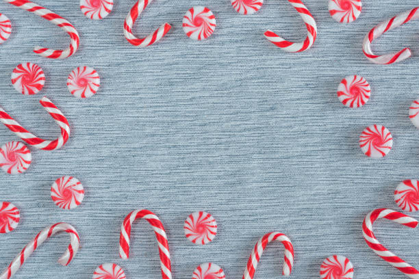 Flat lay frame of Christmas candy canes and peppermint swirl candies Flat lay Christmas frame arrangement with copy space peppermints stock pictures, royalty-free photos & images