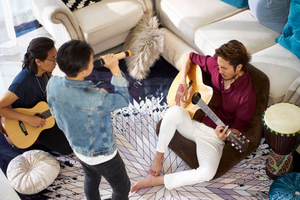 istock young adult men singing playing guitar at home 1170807968