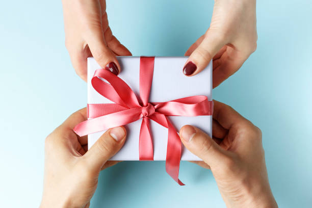 istock Male hands passes gift box to female hands, blue background 1170808675