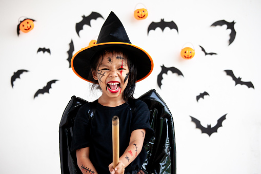 Cute asian child girl wearing halloween costumes and makeup having fun on Halloween celebration