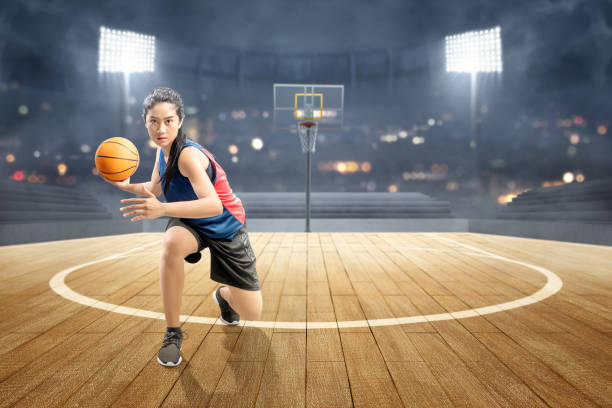 joueur asiatique de basket-ball de femme dans l'action avec la bille - womens basketball photos et images de collection