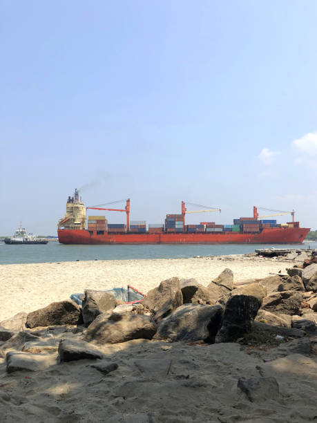istock Image of huge cargo ship entering the Kochin port for cargo loading / unloading down the sea channel, ship is being moored by a tug boat to get into port side Kochi port, Kerala, India 1170821306