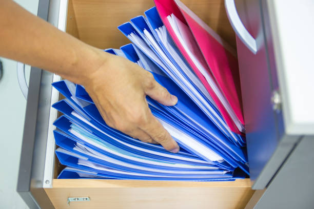 istock Hand of Man Search files document in a file cabinet in work office 1170823067