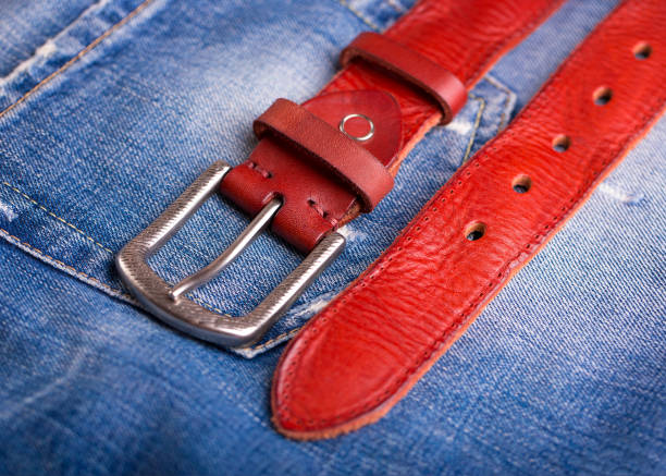 istock A belt lying on denim. Fashionable red belt close-up. 1170823719