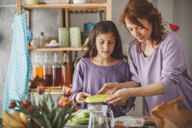 istock Mother and daughter packing a lunch box in the kitchen 1170825508