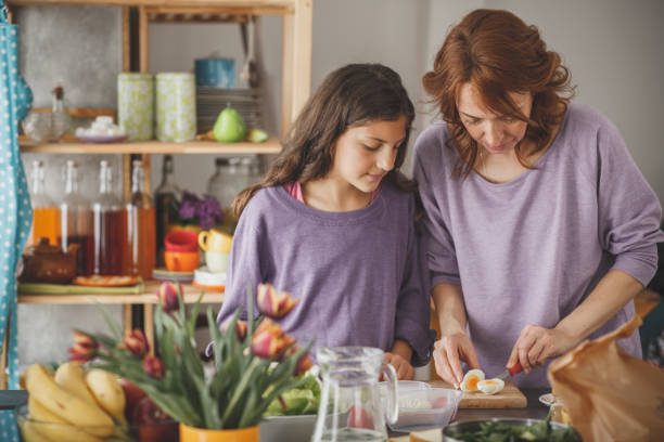 istock Woman cutting boiled egg while preparing a healthy meal 1170825510