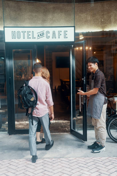 istock Millennial-aged couple entering a hotel while the manager greets them 1170828046