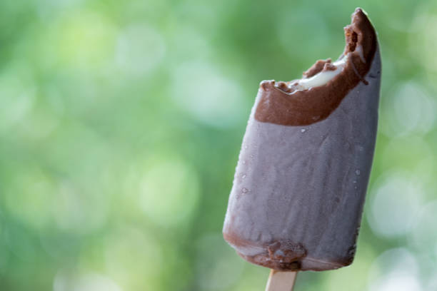 вкусный вкусный с мороженым палкой шоколадный батончик в руке - melting ice cream cone chocolate frozen стоковые фото и изображения