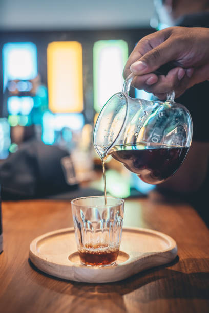 istock drip coffee glass teapot on hand pouring 1170833227