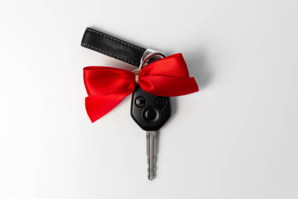 istock Car keys with red bow as present on white background. New car gift concept 1170843204