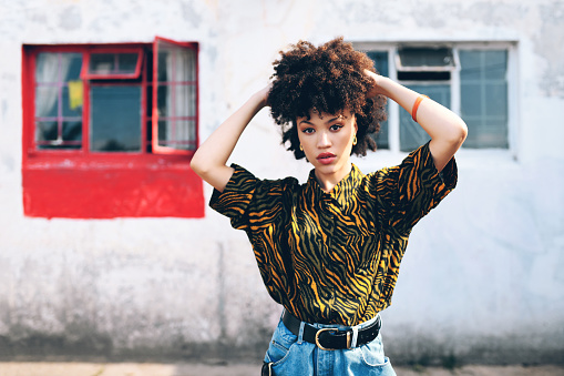 Portrait of an attractive and stylish young woman posing against an urban background