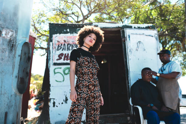 Beautiful stylish young Black woman fashion portrait looking at the camera with serious expression over grey