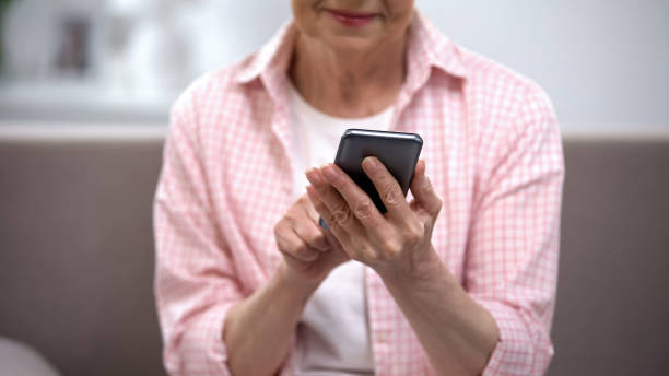 istock Smiling aged woman using smartphone, application for elderly people, technology 1170852838