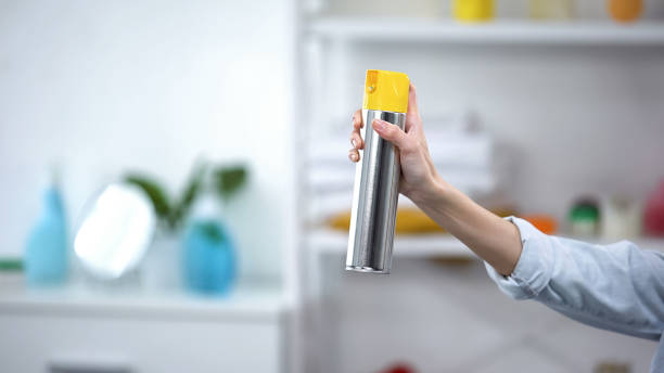 womans hand spraying air freshener in room, nice smell, aroma, housekeeping - air freshener imagens e fotografias de stock