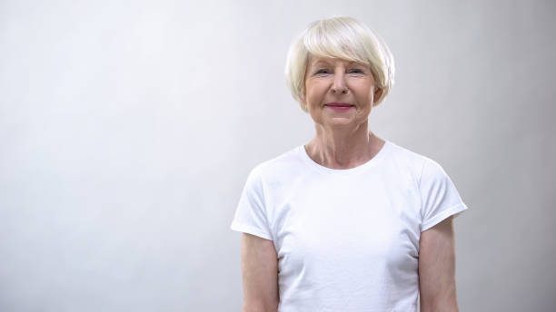 istock Cheerful senior lady looking at camera against grey background, social security 1170853621