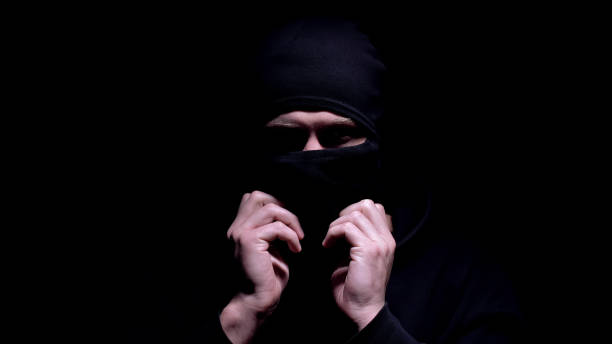 istock Serious man putting on balaclava, preparing for murder or robbery, banditry 1170854261