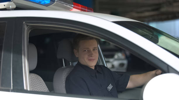 istock Smiling policeman looking at camera from police car, important profession 1170854869