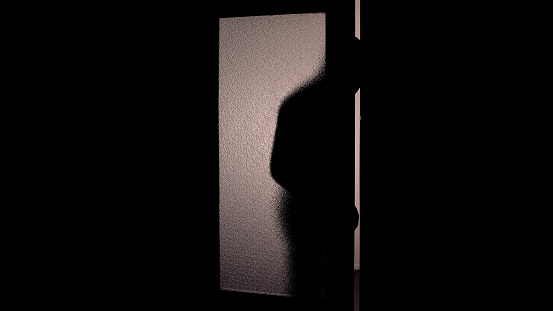 Dark shadow of hooded man opening glass door, danger of burglary dark background