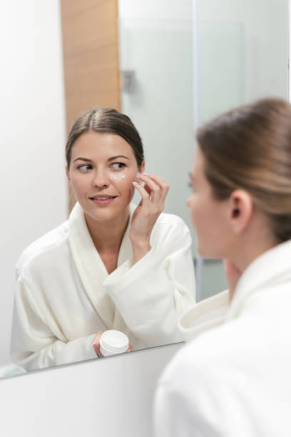 istock Woman holding cream in hands, standing at bathroom 1170856624