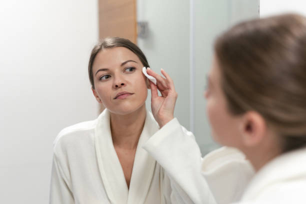 istock Woman in white bathrobe holding cotton pad in hands 1170857167