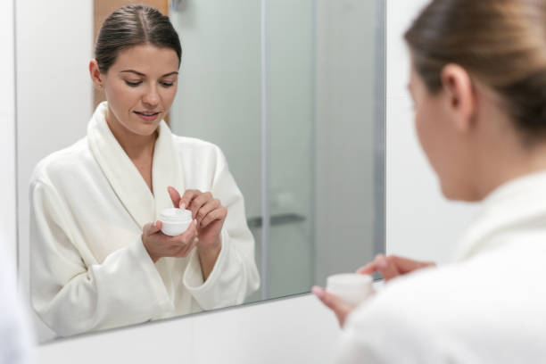 istock Woman holding cream in hands, standing at bathroom 1170857202