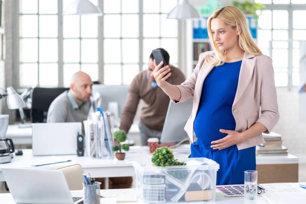 istock Pregnant blond woman taking selfie at workplace 1170858886