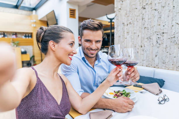 istock Couple dining and drinking red wine in restaurant and taking selfie 1170859107