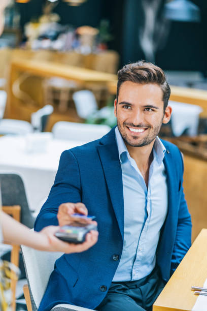 istock Businessman using credit card for contactless payment in restaurant 1170859115