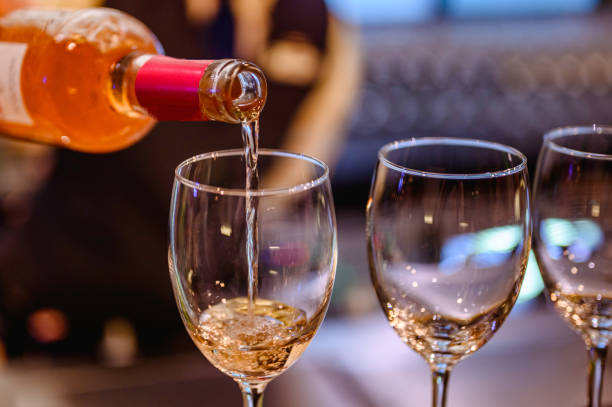 istock Pouring glasses of white wine from a bottle. 1170859166