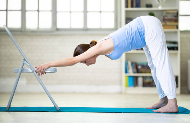 Pregnant woman practicing yoga at home - adho mukha svanasana pose