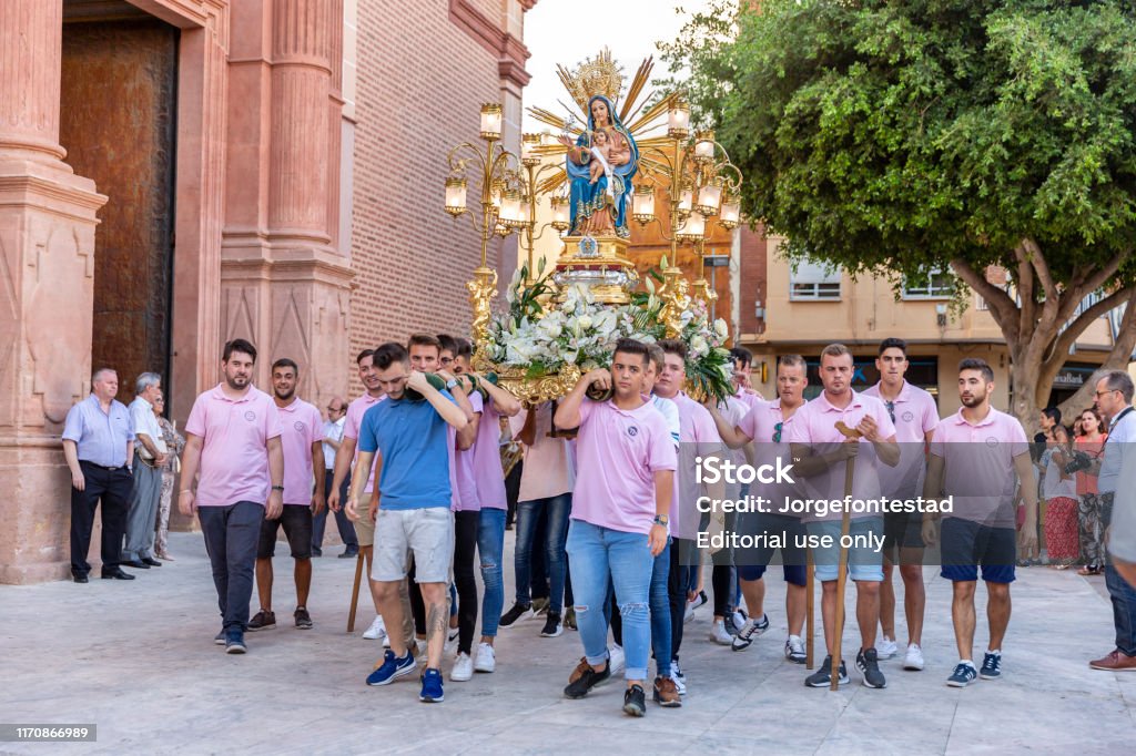 Traditional Virgin procession in Foios, Valencia August 17, 2019. Foios, Valencia, Spain. Traditional procession of the Virgin by the town streets. The young people of the town take the Virgin with a platform and walk by all the streets. This happen all summers because Her saint's day. Architectural Dome Stock Photo