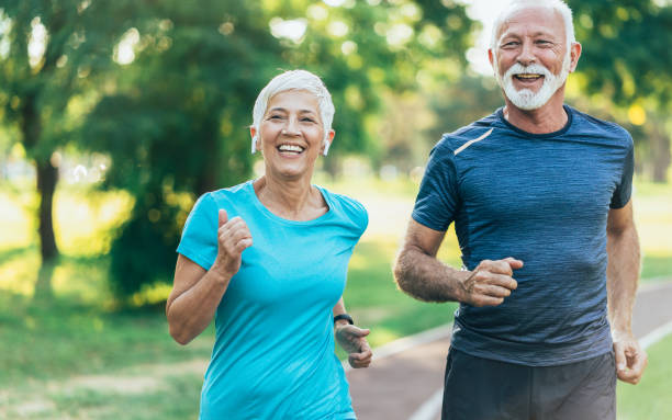Senior couple jogging Senior athletes jogging in the park pedometer photos stock pictures, royalty-free photos & images