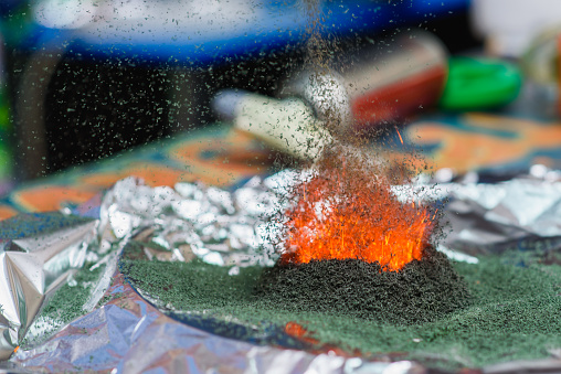 chemical reaction of ammonium dichromate if to set fire to it on the foil