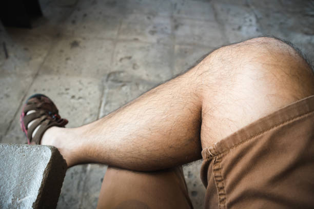 Man in brown shorts chill sitting cross-legged in loft style cafe. Asian male sitting in cafe.