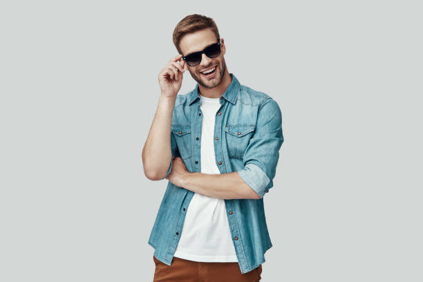 istock Handsome young man looking at camera and smiling while standing against grey background 1170874543